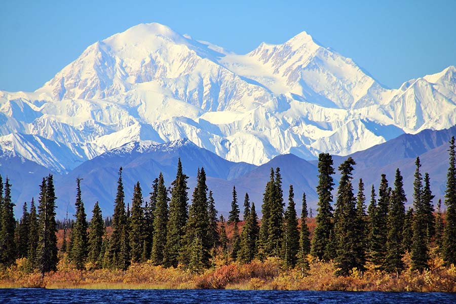 Alaska Cannabis Insurance - View of Glaciers on Mountain Top and Surrounding Forests and Lake in Alaska