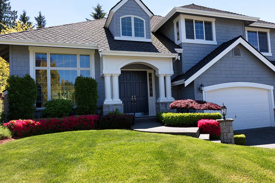 Home Insurance in Washington - Exterior of a Modern Two Story Home with an Attached Garage and Green Landscaped Front Yard