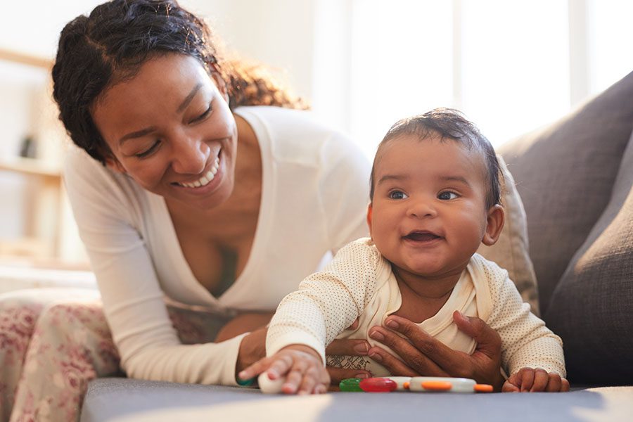 Individual Life Insurance - Portrait of a Smiling Mother and Her Baby Playing Together at Home