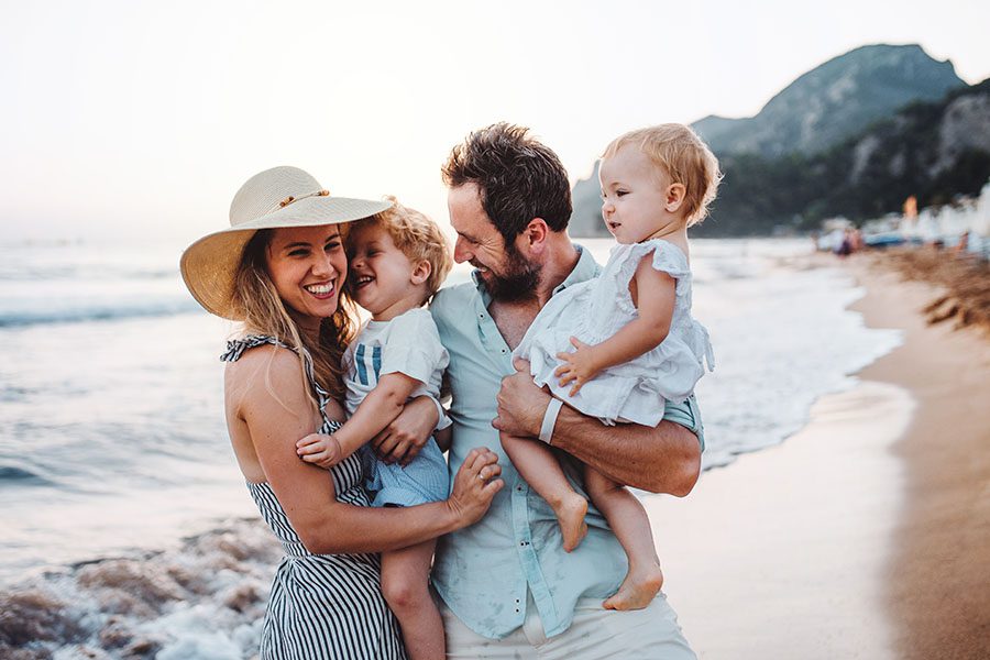 Personal Insurance - Portrait of a Family and Two Kids Having Fun Visiting the Beach During Summer Vacation