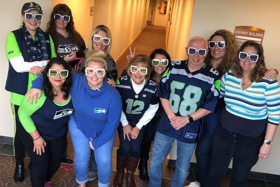 About Our Agency - Photo of Mosaic Insurance Team Posing in the Office Wearing Sports Jerseys and Funny Glasses