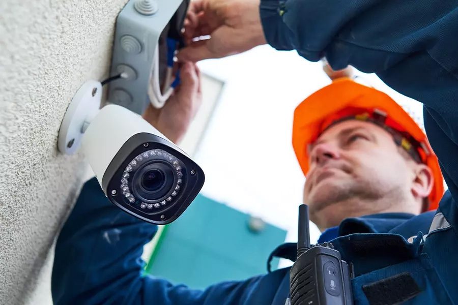 Alarm-Contractor-Insurance-Alarm-Technician-Worker-Installing-Video-Surveillance-Camera-on-a-Wall